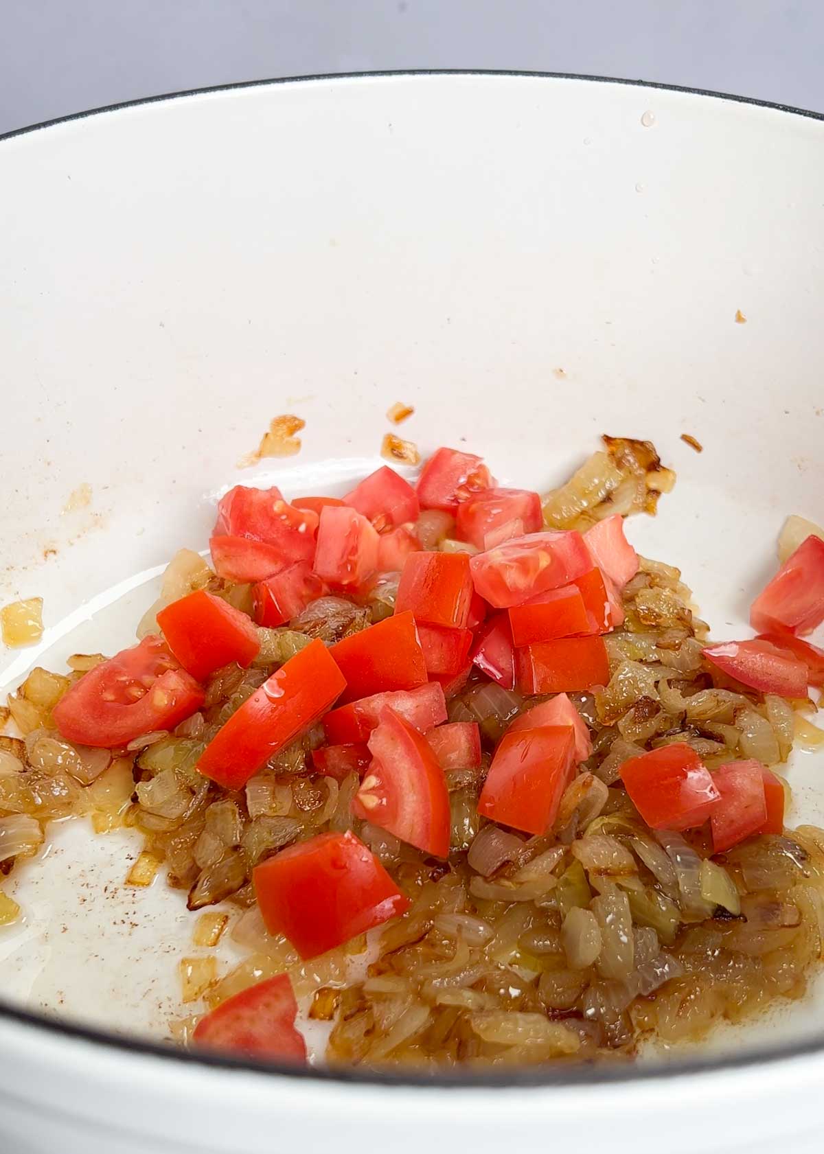fresh tomato in a pot of caramelised onions