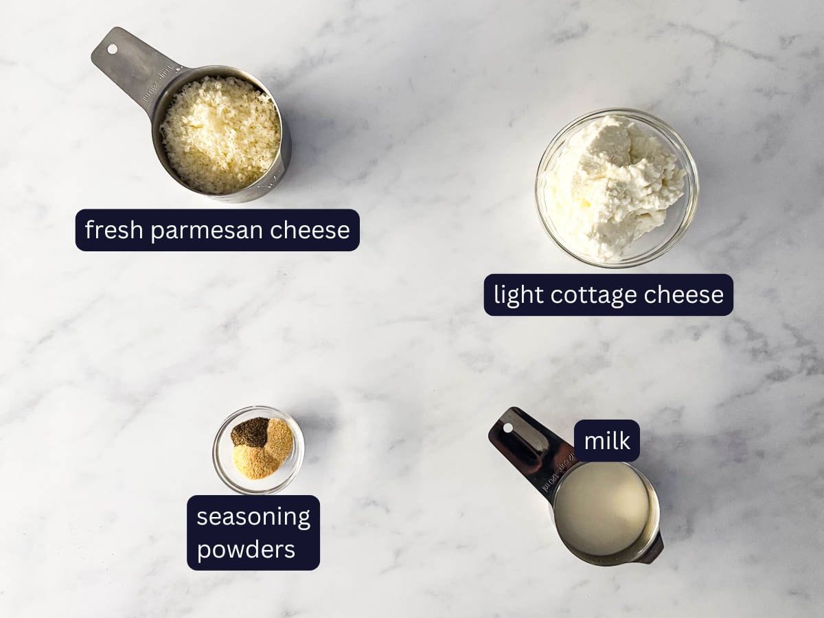 30 minute high protein skillet lasagna, whipped cottage cheese sauce ingredients from the top view, including freshly grated parmesan cheese, light cottage cheese, seasoning powders and milk.