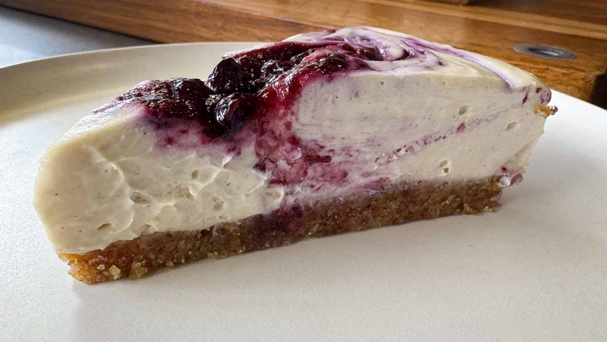 slice of vegan no bake cheesecake on white plate. 